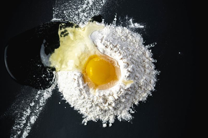 flour and egg on a black table