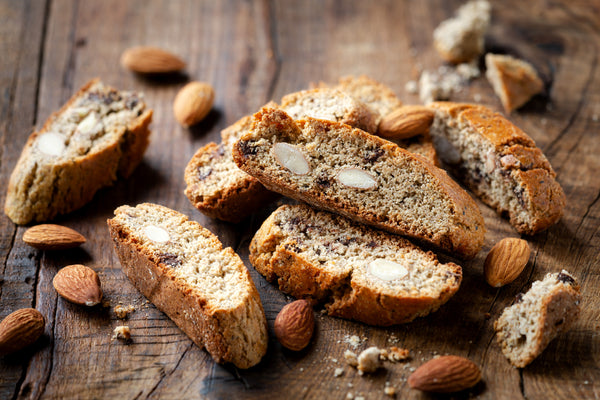 a pile of biscotti and almonds on a wood surface