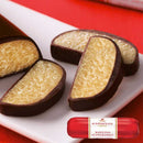 Slices of Niederegger Marzipan on a plate with the wrapped bar showing the brand's label.